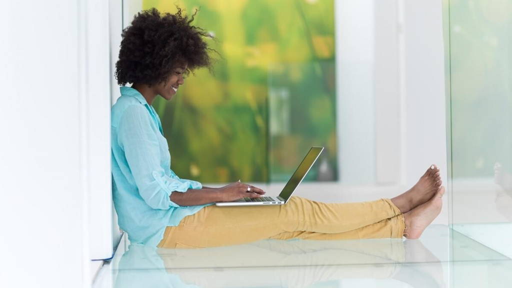 black women using laptop computer on the floor