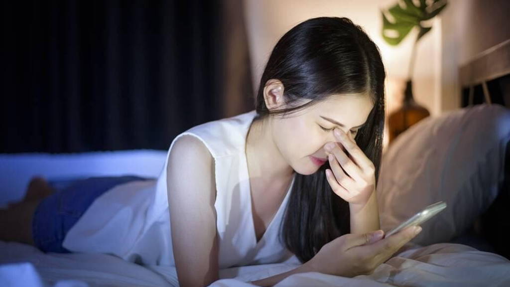 vrouw-bed-smartphone-pijn