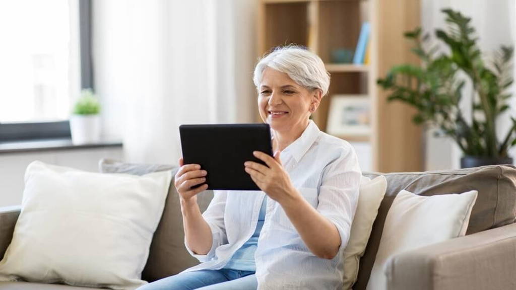 happy senior woman with tablet pc at home