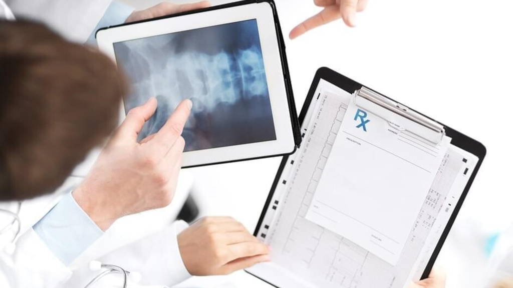group of doctors looking at x-ray on tablet pc