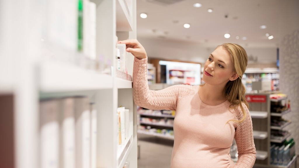 pregnant woman at pharmacy or cosmetics store