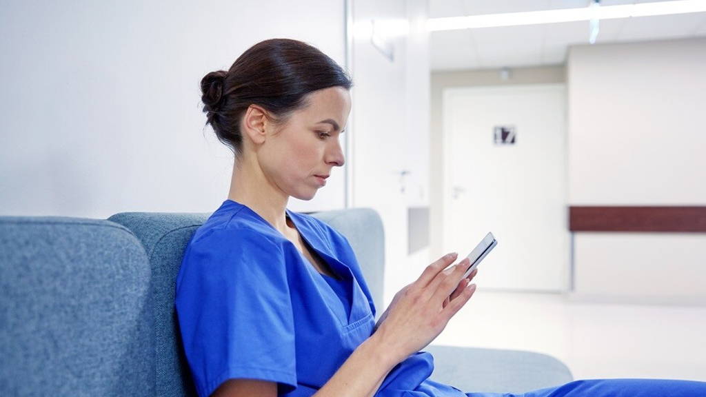 female doctor or nurse with smartphone at hospital