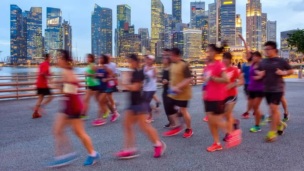 Joggers on illuminated Singapore promenade