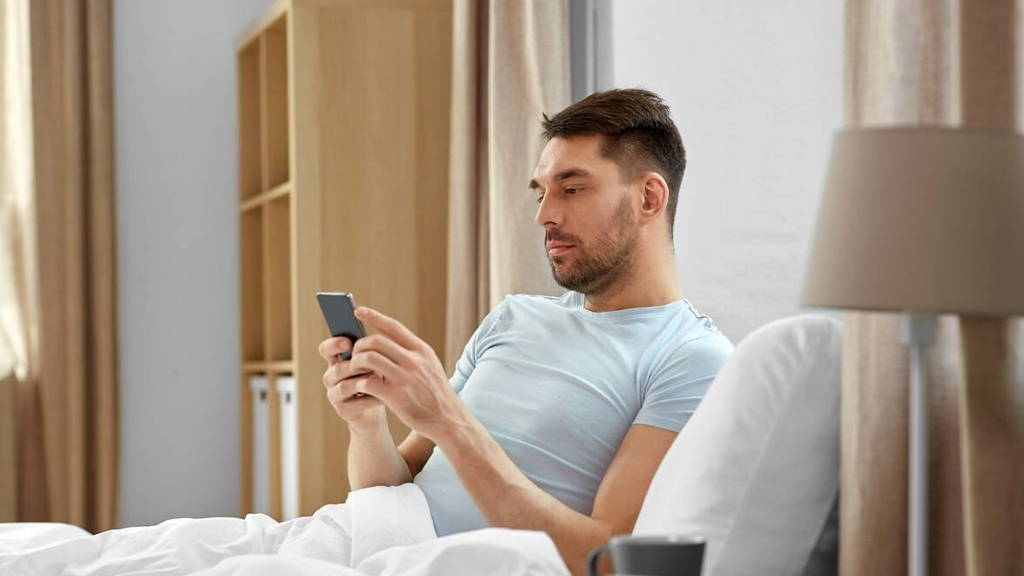 Man-bed-smartphone