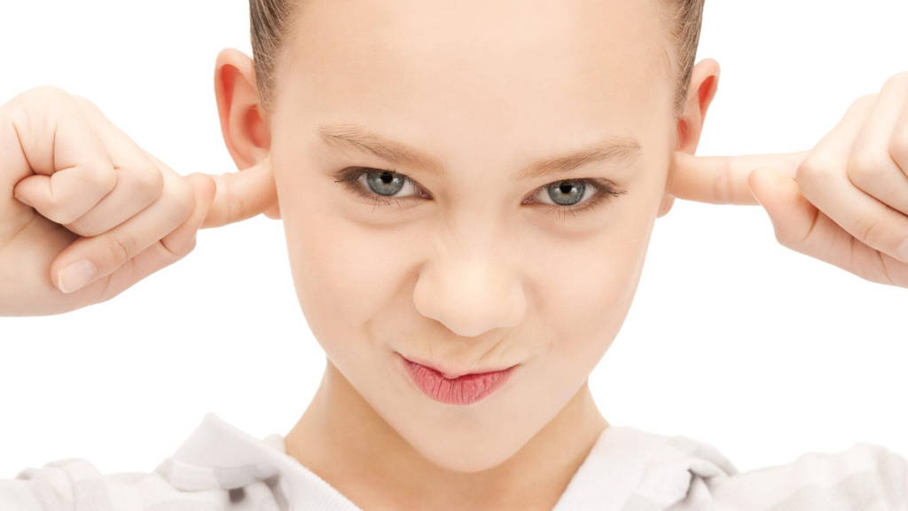 teenage girl with fingers in ears
