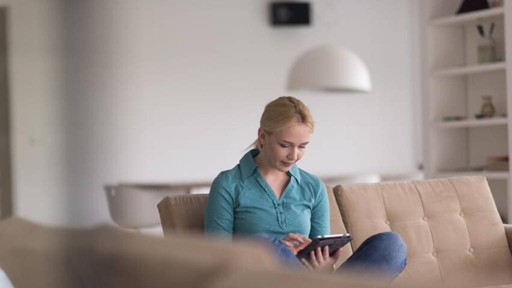 woman on sofa using tablet computer