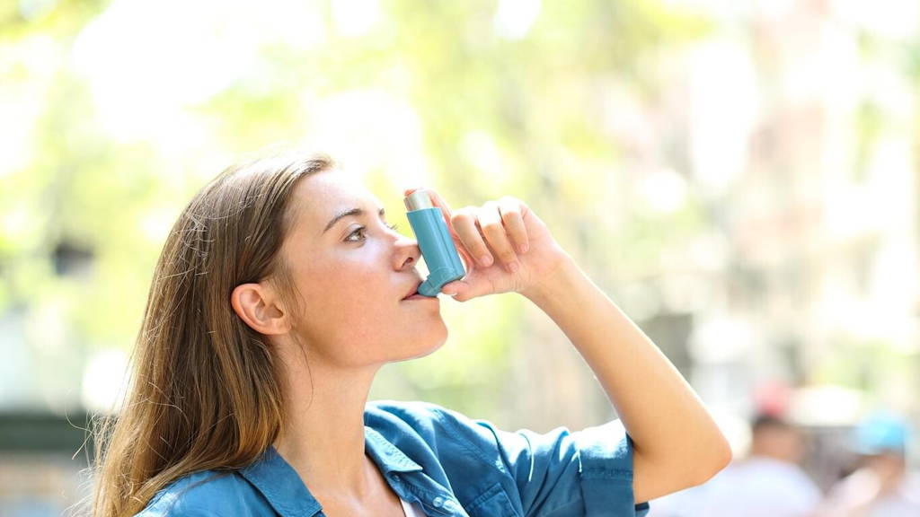 Asthmatic woman using a inhaler outdoors